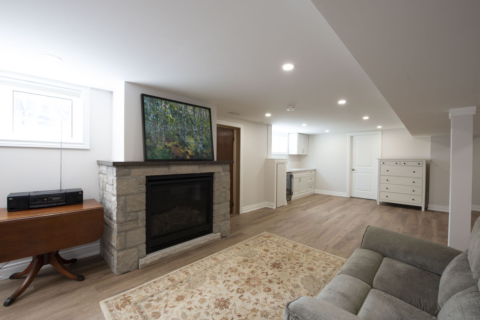 Finished basement with stone fireplace by AC Custom Reno